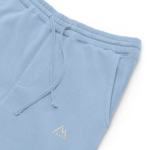 Mountain Faith Co. light blue joggers close-up showing embroidered mountain logo and pocket detail