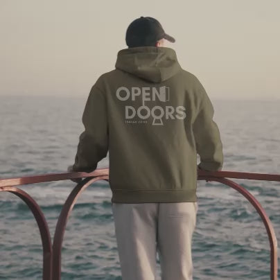 Video of a man wearing the Mountain Faith Co. Open Doors Hoodie, walking outdoors and showcasing the ‘Open Doors’ design inspired by Isaiah 22:22.